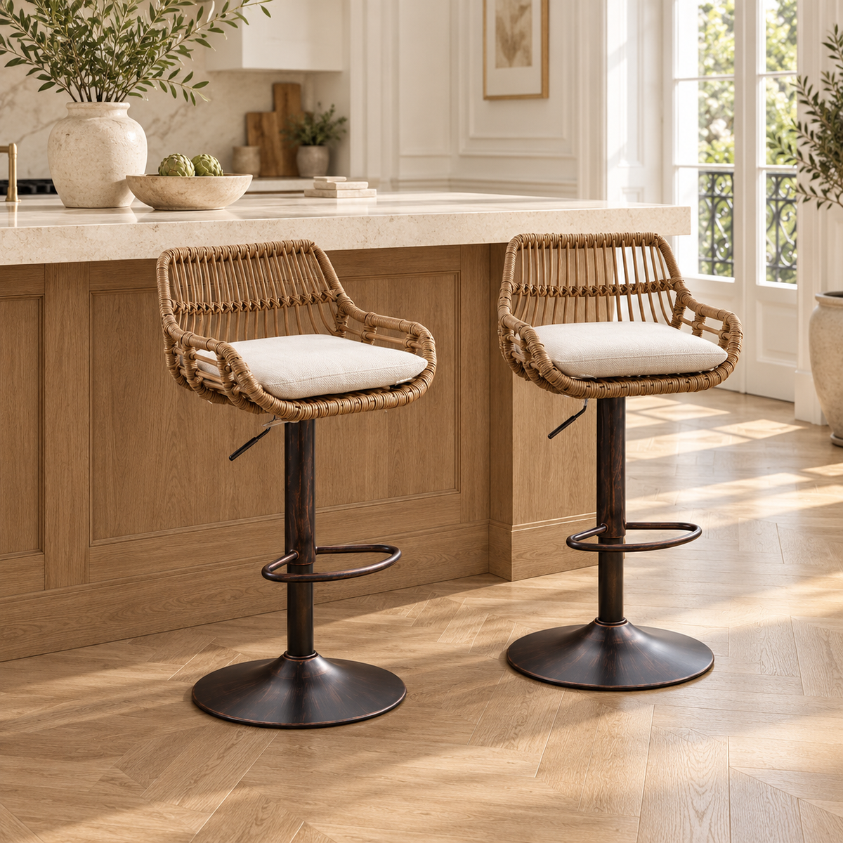 Deux fauteuils de bar tressés avec coussin blanc devant un îlot en bois et pierre dans une cuisine lumineuse.