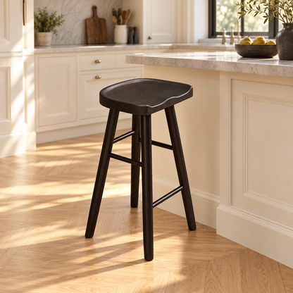 Tabouret à assise incurvée finition noir de 55 cm dans une cuisine lumineuse.