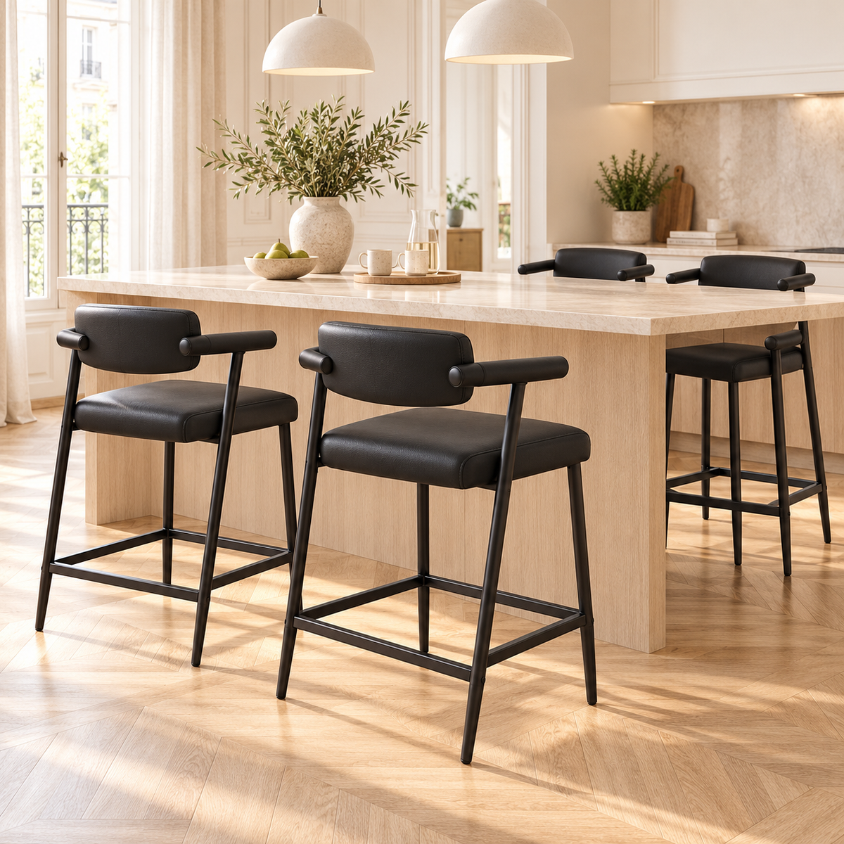 Quatre tabourets noirs à dossier bas autour d’un îlot dans une cuisine lumineuse avec parquet en chevrons.