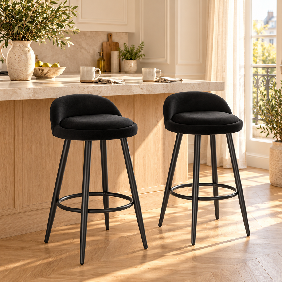 Deux tabourets noirs en velours à pieds fins dans une cuisine lumineuse