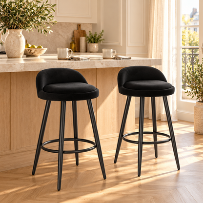 Deux tabourets noirs en velours à pieds fins dans une cuisine lumineuse